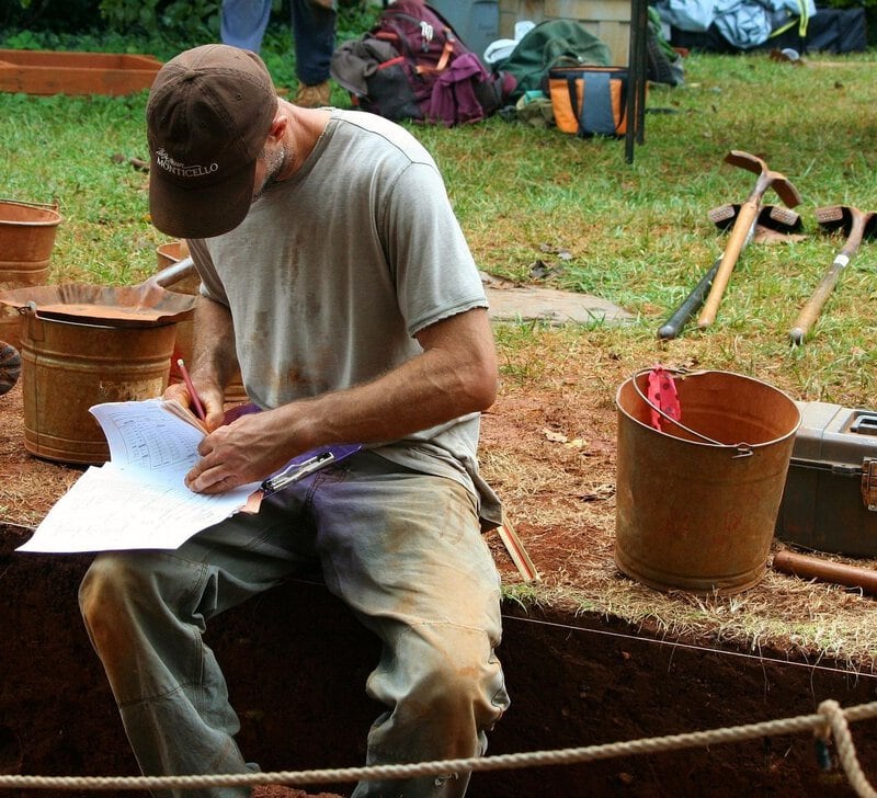 An archaeologist documenting findings at an active dig site directly matches the section