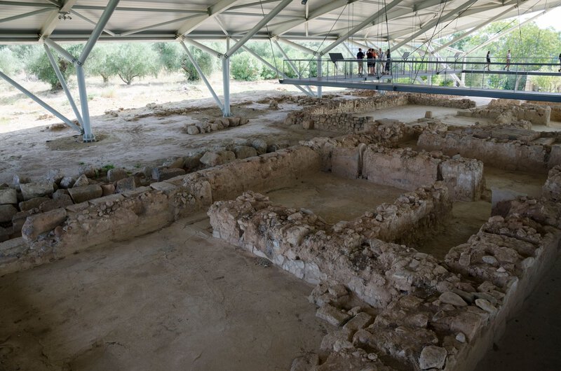 Shows the Palace of Nestor ruins at Pylos with visitors visible, giving scale and editorial context to the excavation site.
